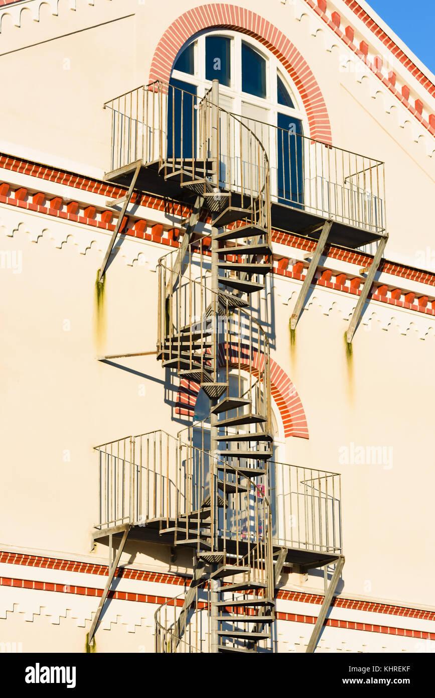 Spirale Feuertreppe außerhalb eines Gebäudes. Balkonen auf jeder Etage. Stockfoto