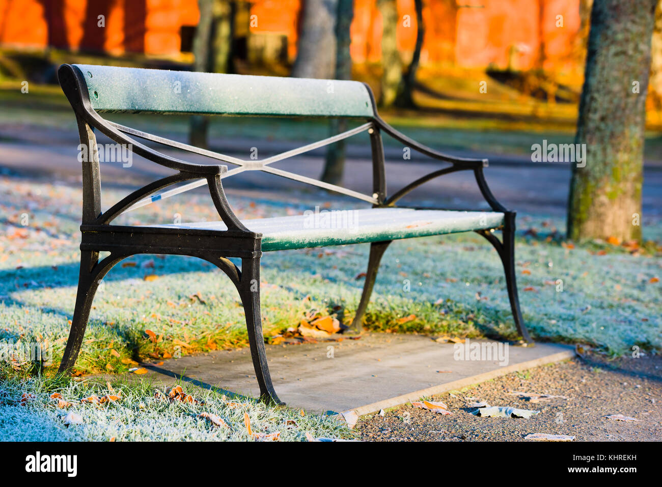 Frost bedeckt Sitzbank im Morgenlicht in den öffentlichen Park. Stockfoto