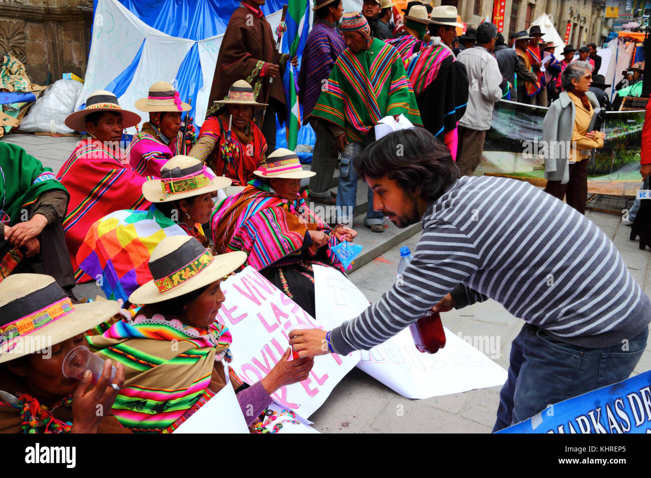 Ein Protest Veranstalter gibt Getränke CONAMAQ indigene Völker union Mitglieder während der Proteste gegen die Pläne, eine Straße in der TIPNIS, Bolivien zu bauen Stockfoto