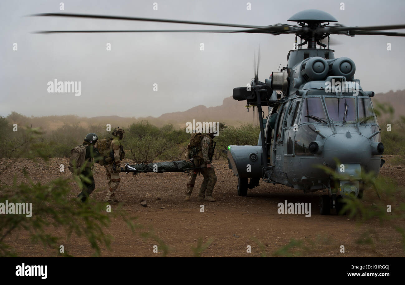 Ein US Air Force pararescuemen zugeordnet. bis 48 Rescue Squadron und französische Air Commandos einen simulierten Patienten zu einem Eurocopter EC-725 für Aeria bewegen Stockfoto