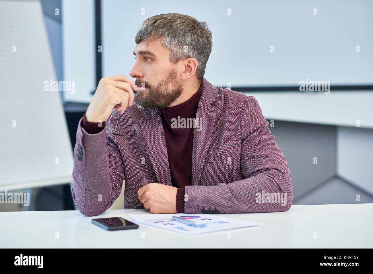 Profil ansehen Portrait von eleganten reifer Mann mit grauem Haar am Besprechungstisch im Büro hören Sitzung Diskussion zu arbeiten Stockfoto