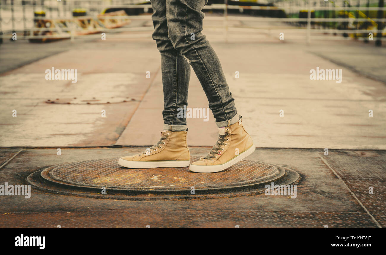 Männliche Beine in Grau jeans und Leinwand Stiefel outdoor. fashion street Foto, Farbton. Stockfoto