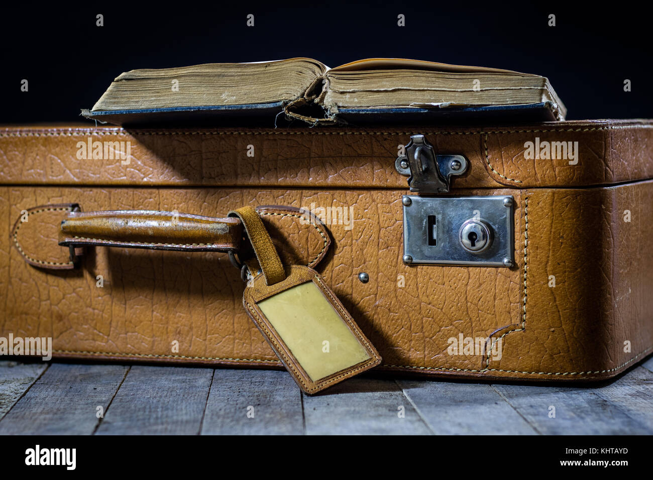 Alte stilvolle Koffer. alte Bücher in einem Koffer. Koffer auf einem Holztisch. schwarzer Hintergrund Stockfoto