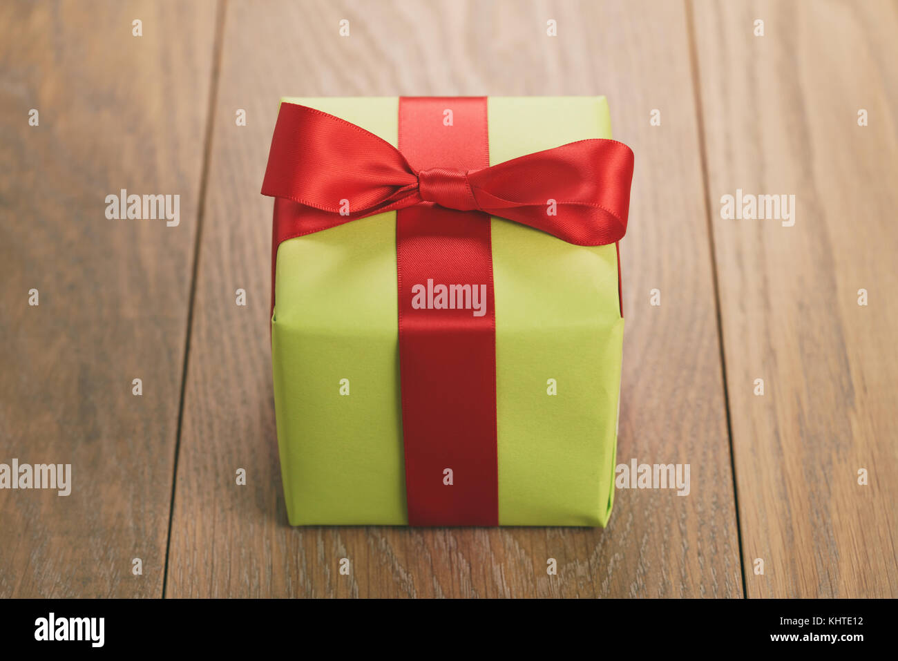 Grünbuch Geschenkbox mit roter Schleife auf Eiche Tisch Stockfoto