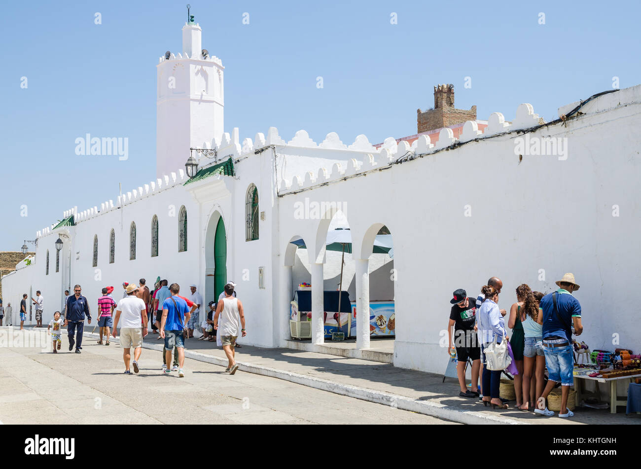 Ouarzazate, Marokko - 14. August 2013: Unbekannter Touristen wandern und Shopping vor Weiße Moschee und Stadtmauer Stockfoto