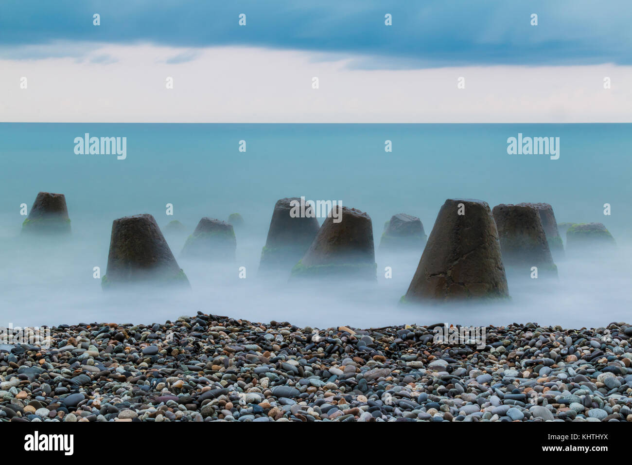 Lange Belichtung Foto der konkreten konische Felsbrocken im Meer in der Nähe des Strandes liegen Stockfoto