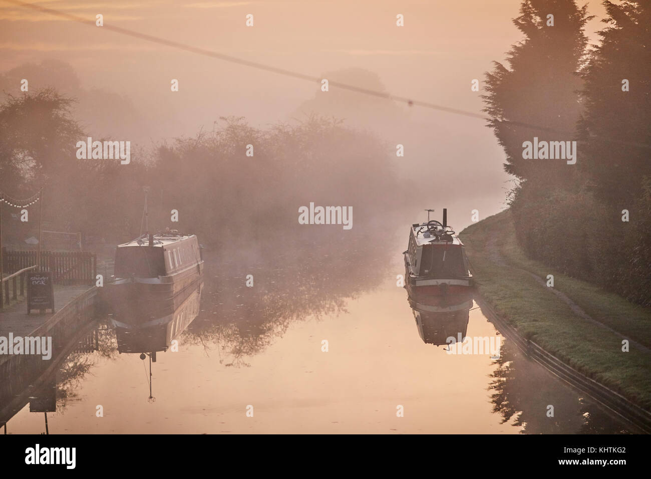 Herbst Nebel Nebel Cheshire, Tiverton, Tarporley. Narrowboats festgemacht an der Seite des schattigen Eiche Pub auf dem Shropshire Union Canal Stockfoto