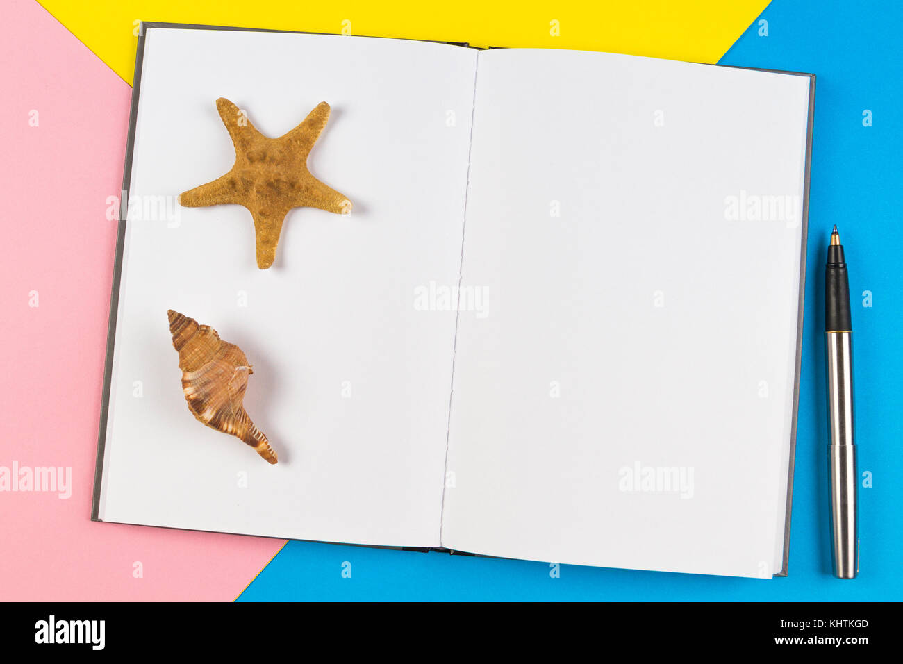 Notebook mit Muscheln und Seesterne auf blauem Hintergrund. Urlaub, Reise Konzept. Stockfoto