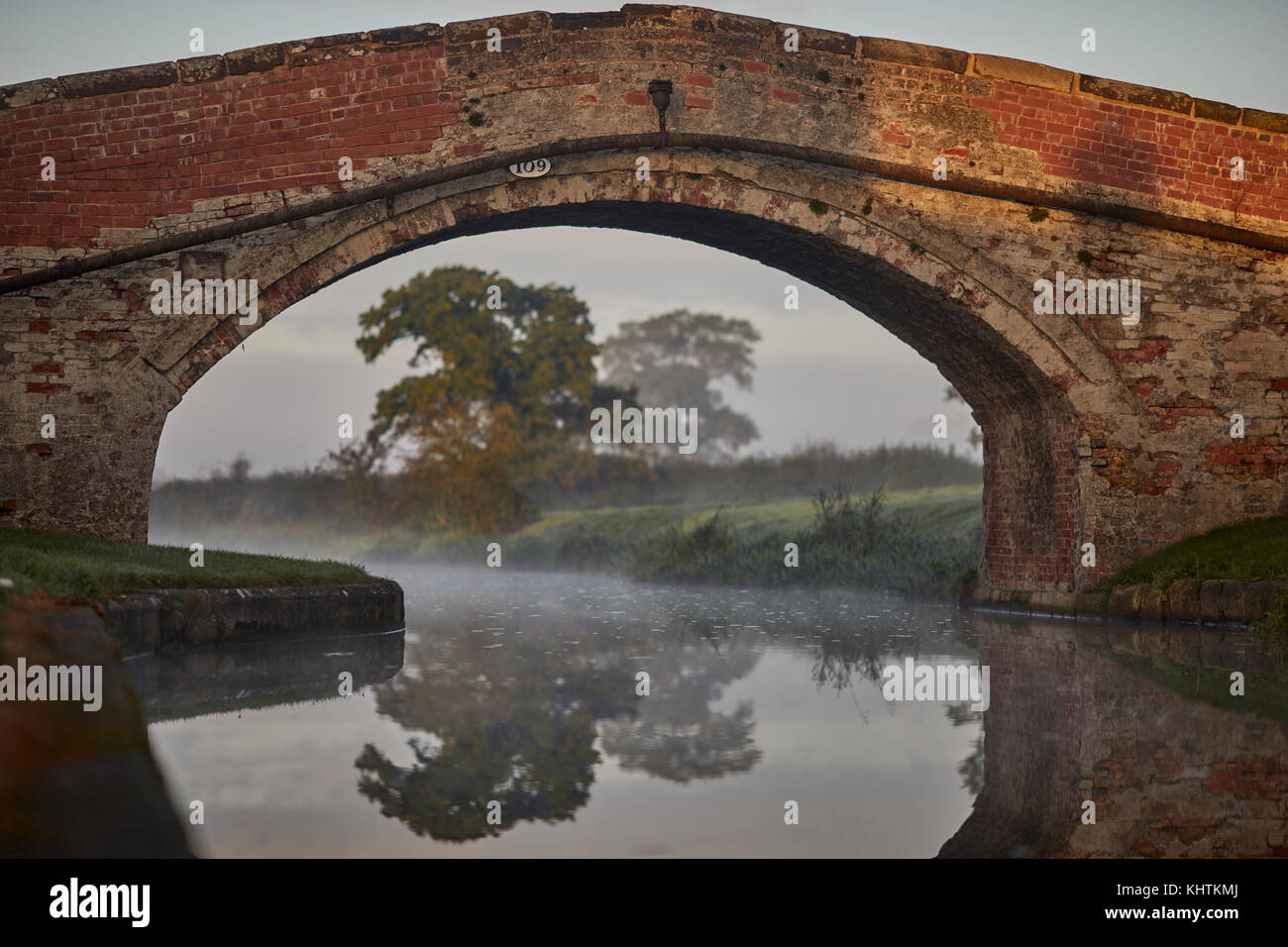 Herbst Nebel Nebel Cheshire, Tiverton, Tarporley. schmale Straße die Shropshire Union Canal Kreuzung durch eine schmale gemauerte Brücke Stockfoto