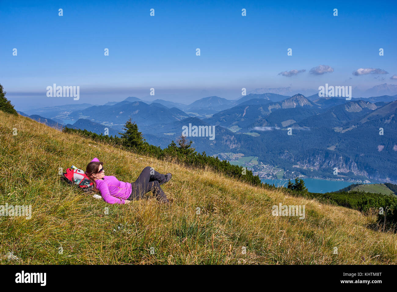 Frau entspannend auf Gras in den Bergen Stockfoto