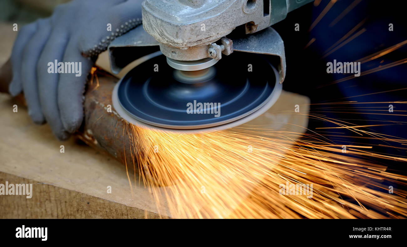 Arbeiter Schneiden von Metall mit Schleifer. Funken beim Schleifen Bügeleisen Stockfoto