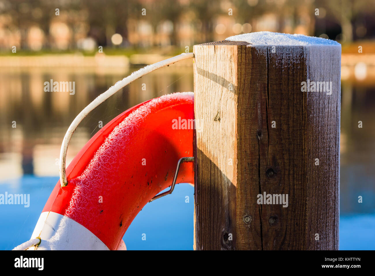 Detail der frostigen Rettungsring auf einem hölzernen Pfosten mit dem See im Hintergrund. Stockfoto