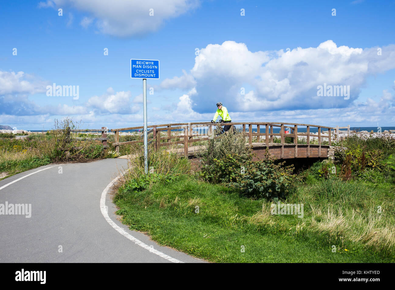 Radfahrer steigen Schild, vor Brücke, auf Wales Coast Path UK Stockfoto