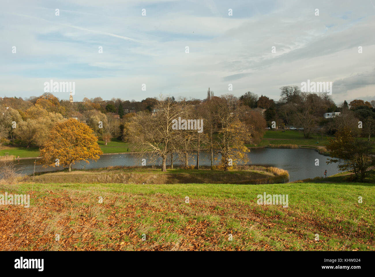 Blick über das Modell bootfahren Teich, Hampstead Heath mit warmen Farben des Herbstes auf den See, Bäume und Wiese. highgate in der Ferne. Stockfoto