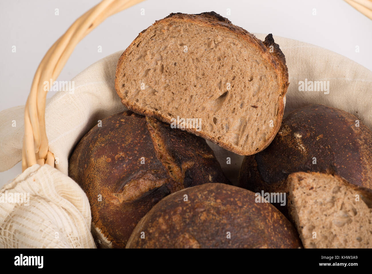 Frisch gebackenen Laibe von Runden artisan Sauerteig Vollkornbrot in einem brotkorb. Stockfoto