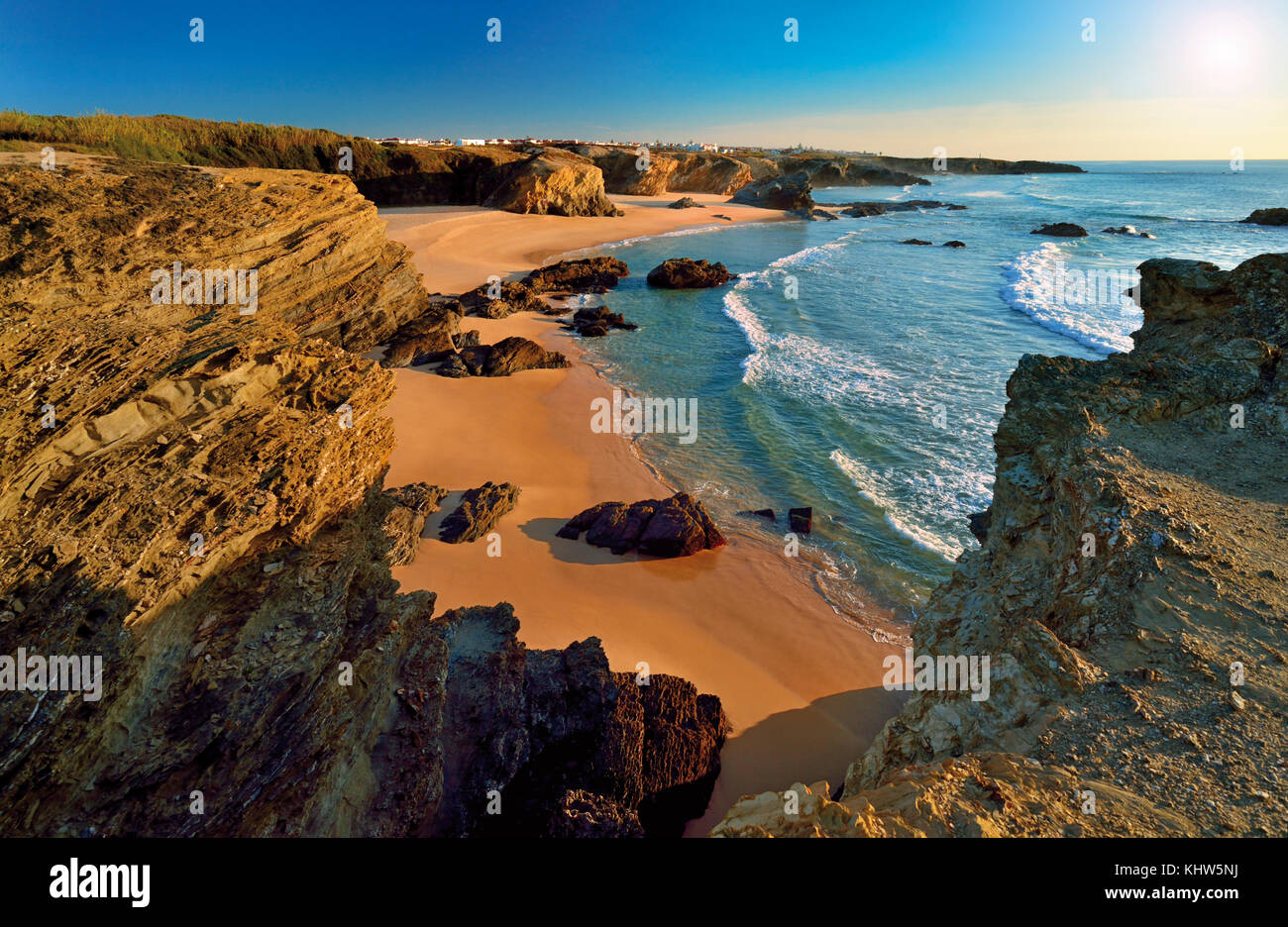 Blick auf die Küste auf den natürlichen felsigen Strand mit beigefarbenem Sand und schieferartigen Klippen Stockfoto