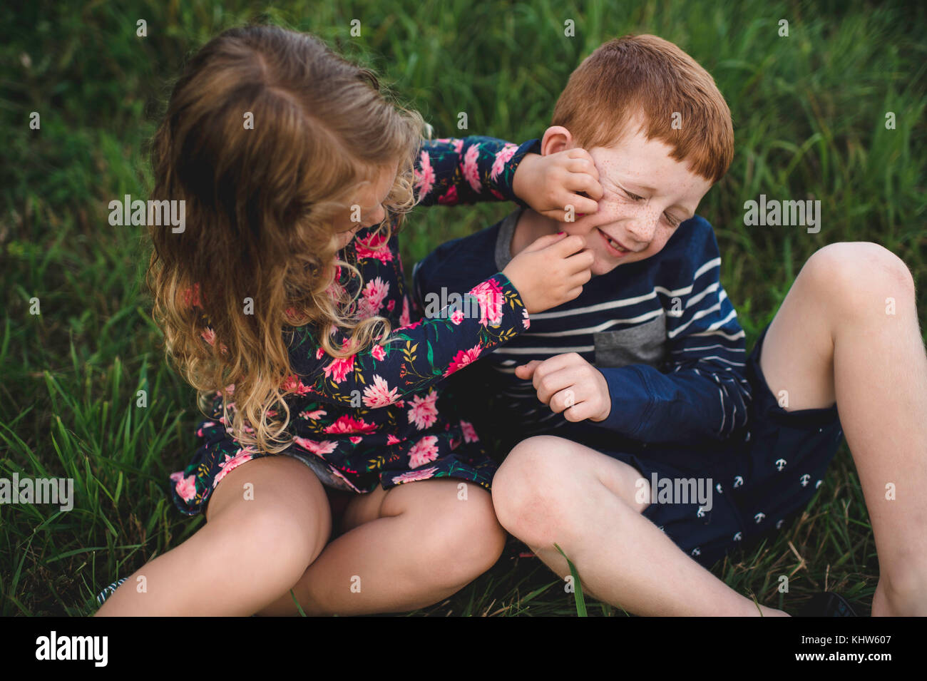 Junge und Schwester spielen Kämpfen im Feld Stockfoto