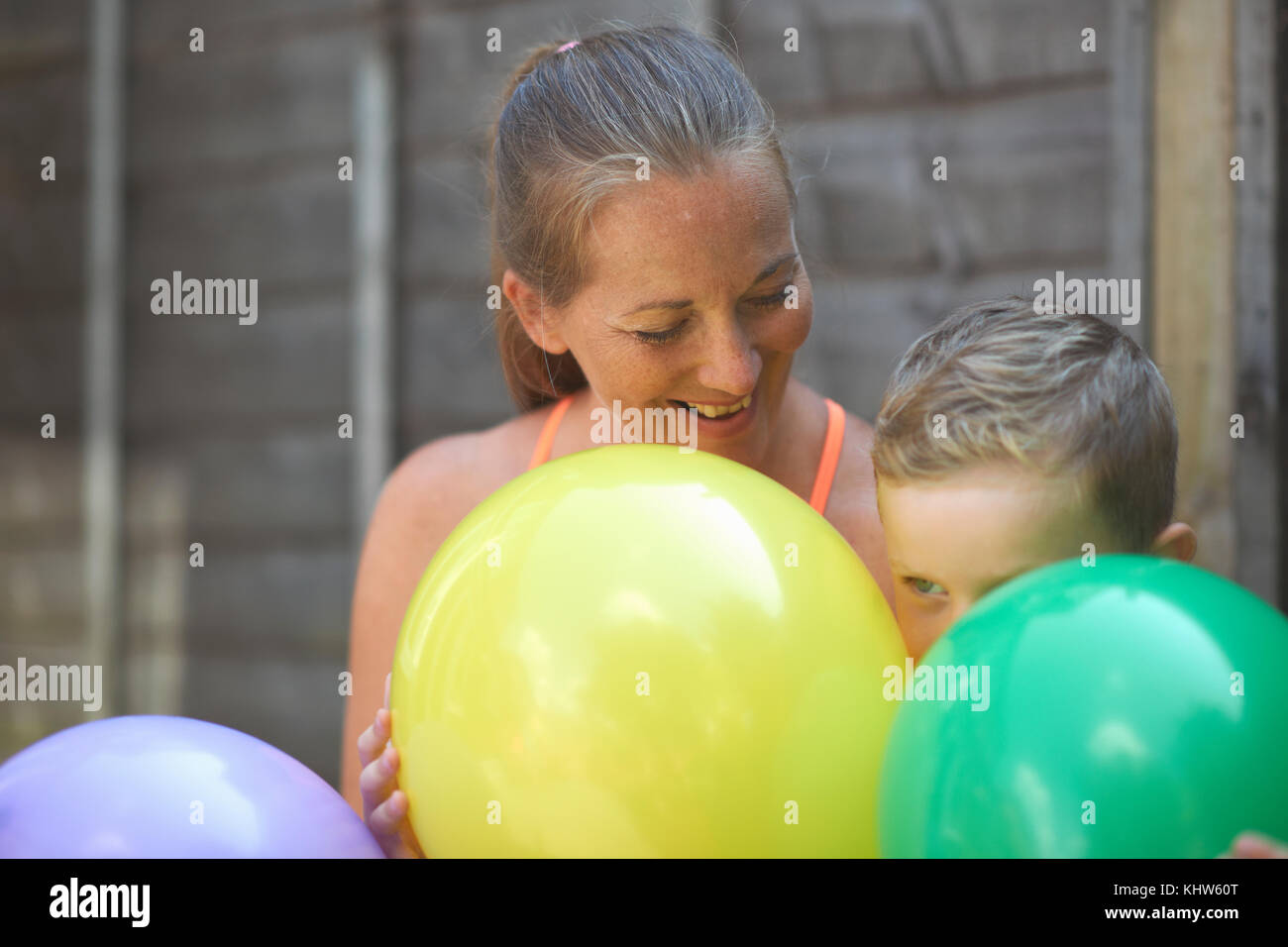 Mutter und Sohn im Garten, holding Ballons Stockfoto