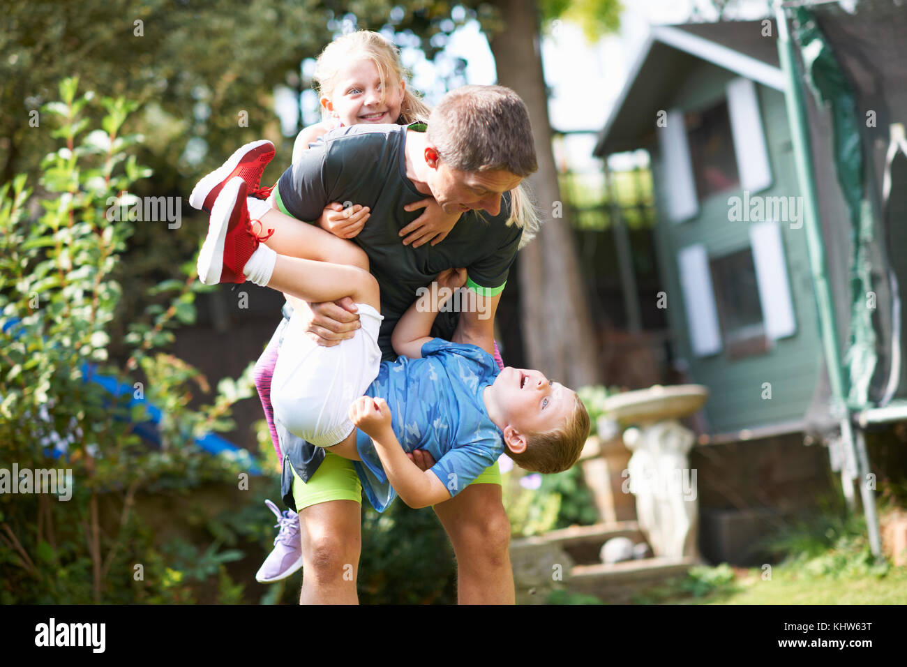 Familie playfighting im Garten Stockfoto