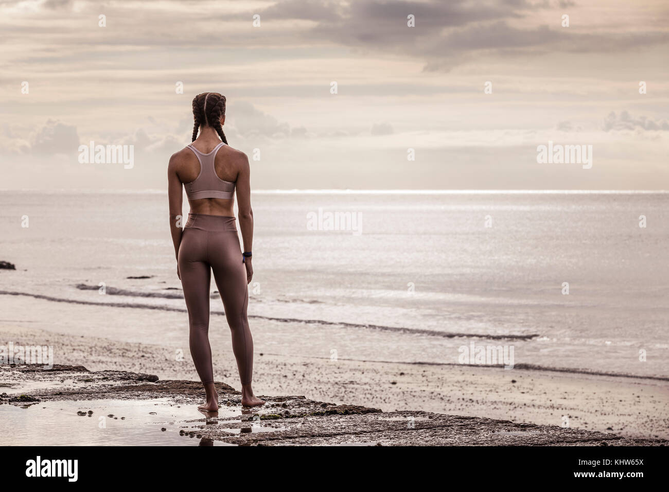 Ansicht der Rückseite des jungen Läuferin an der Wasserkante mit Blick auf das Meer Stockfoto