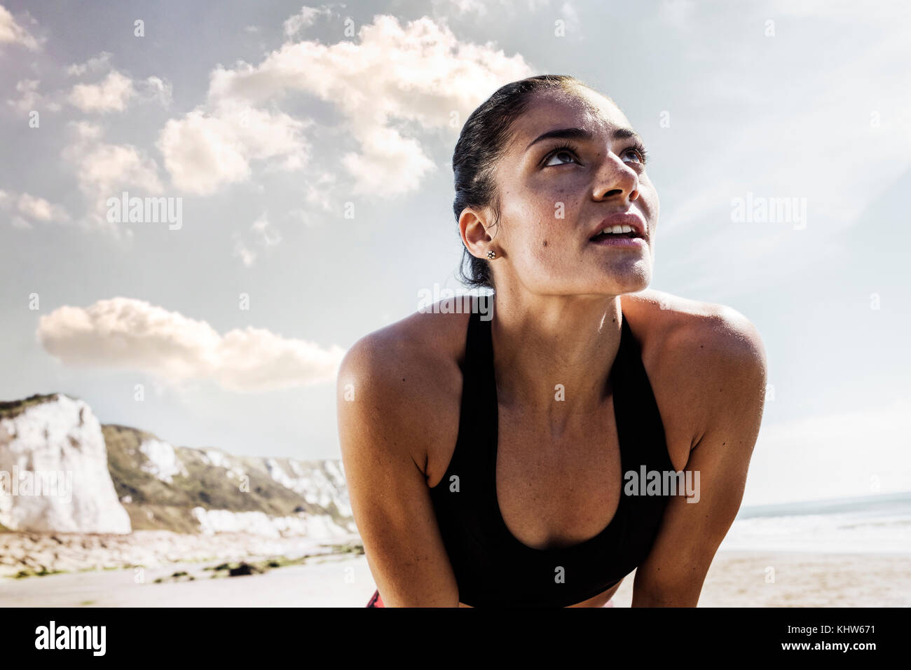 Junge Läuferin eine Pause am Strand erschöpft Stockfoto