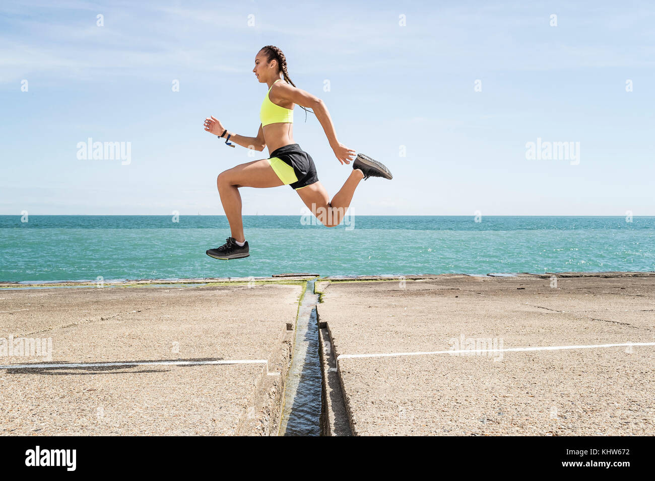 Junge Frau läuft im Freien, über Lücke in der Brücke springen, der Luft Stockfoto