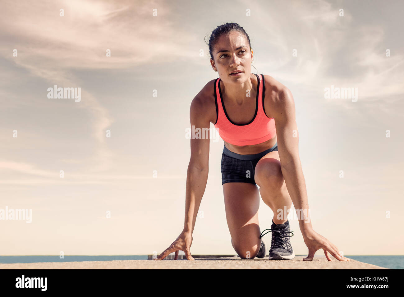 Junge Frau auf Sea Wall, in der Stellung START befinden, wird vorbereitet Stockfoto