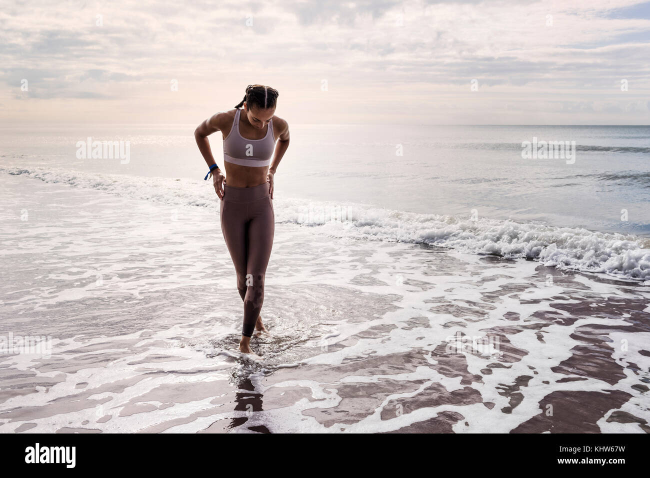 Junge Frau zu Fuß im Meer Stockfoto