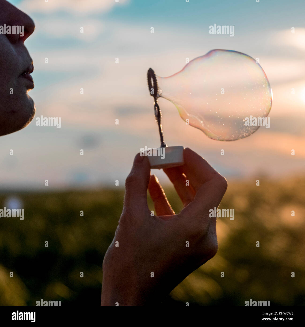 Frau bläst Seifenblasen bei Sonnenuntergang, Ural, Sverdlovsk, Russland Stockfoto
