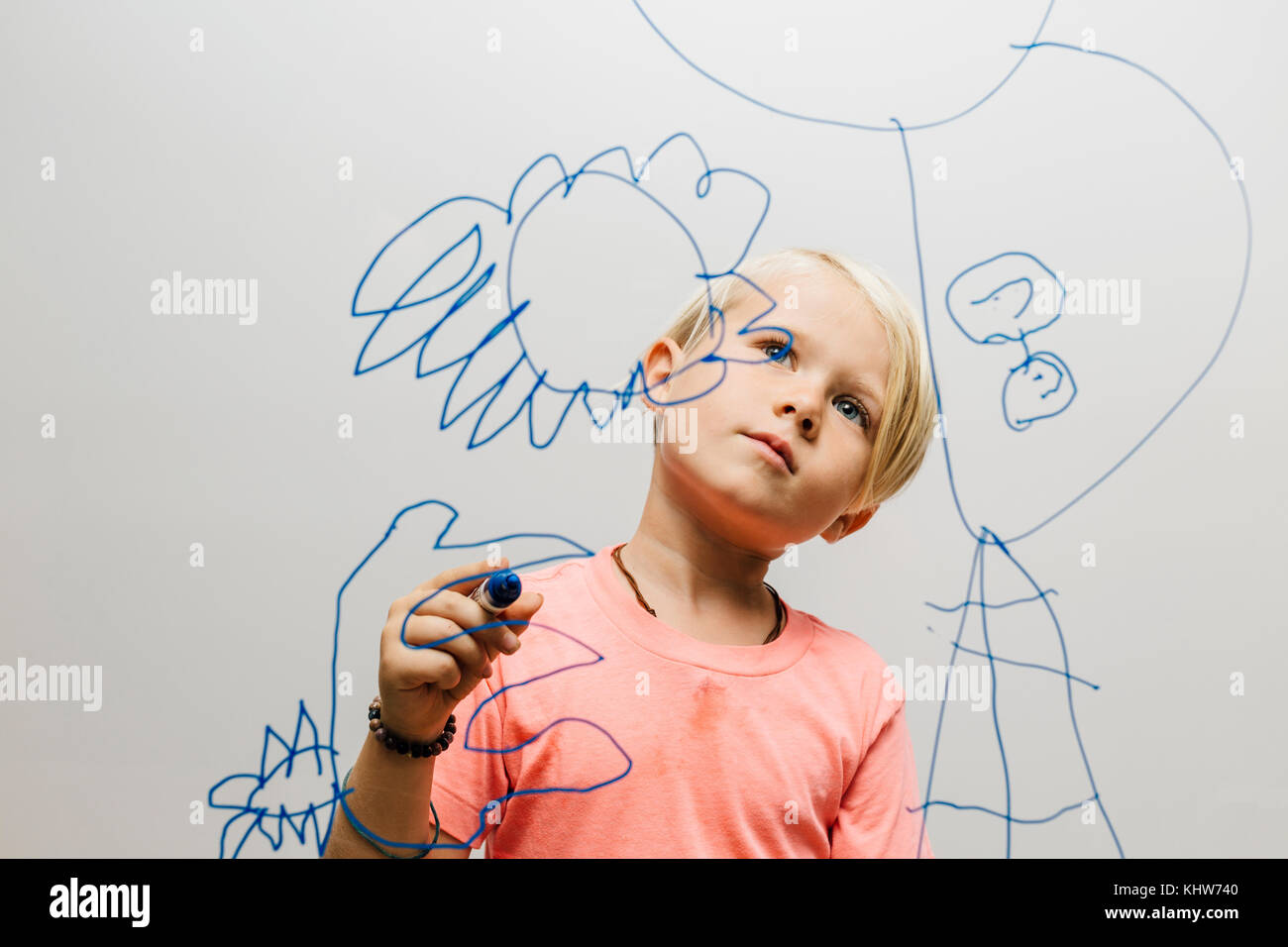 Junge bewundern seine Marker Pen Zeichnen auf Glas Wand Stockfoto
