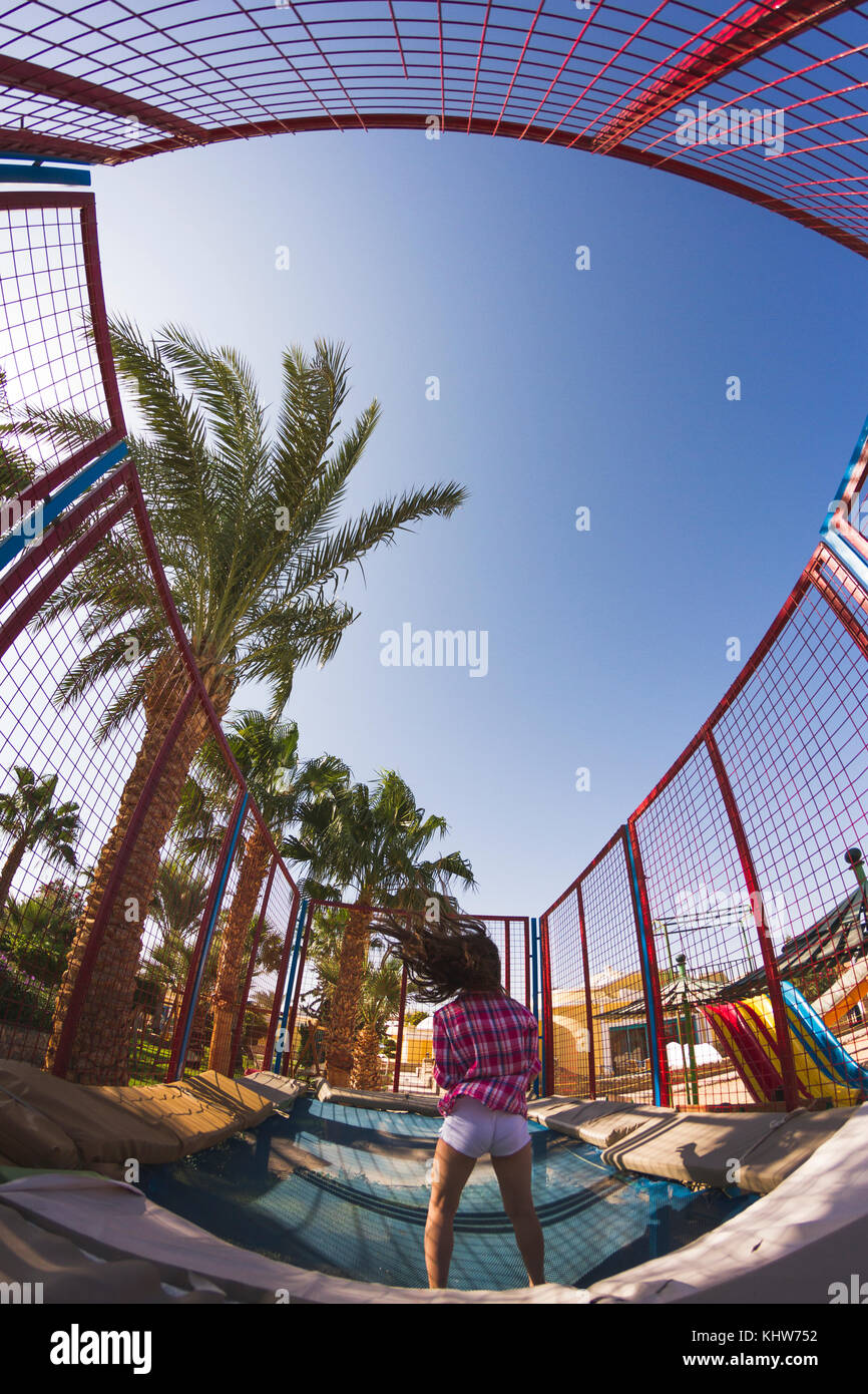 Ansicht der Rückseite des Mädchen Springen auf einem Trampolin spielen Park Stockfoto