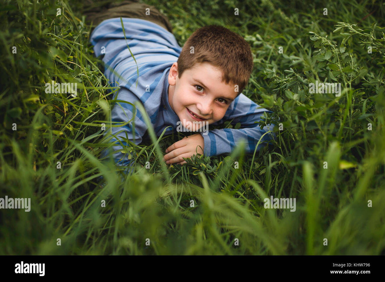 Jungen auf der Suche oben an der Kamera auf der grünen Wiese Stockfoto