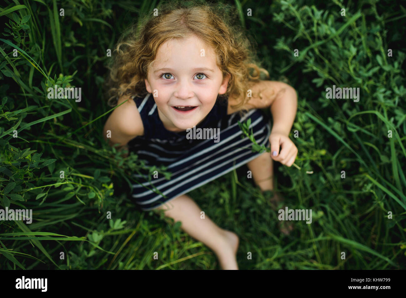 Mädchen, die an der Kamera auf der grünen Wiese Stockfoto