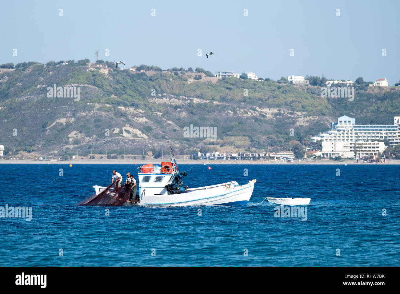 Fischer auf einem kleinen Boot schleppen in einem Fischernetz voll frisch braten, kleinen Fischen. Diese landete und sofort an der Straße seiten Ständen verkauft. Stockfoto