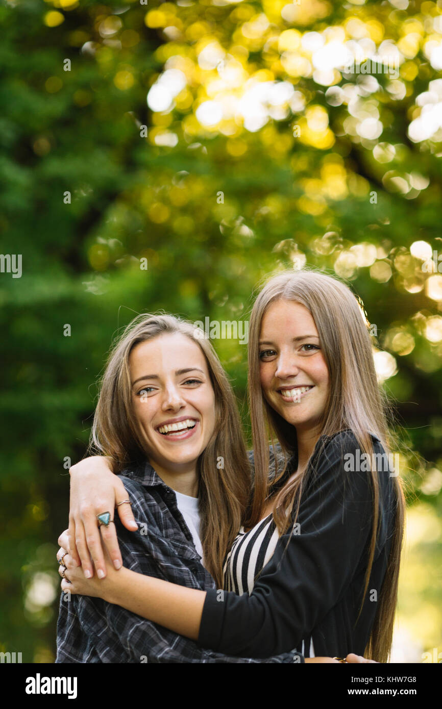 Porträt von zwei Junge weibliche Freunde umarmen in Park Stockfoto