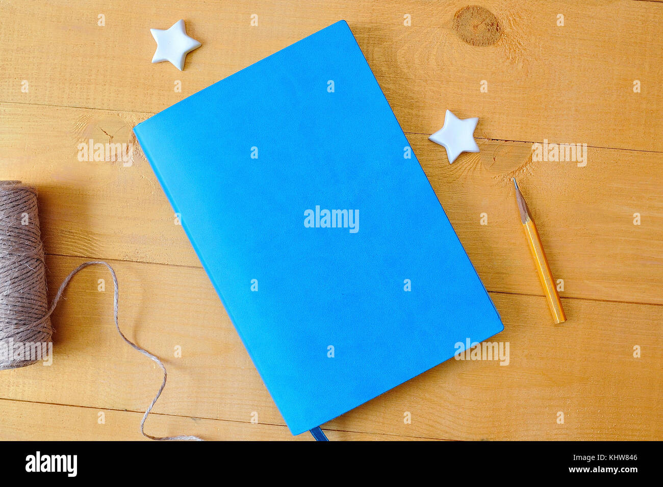 Blaues Notizbuch mit bunten Bleistiften auf Holztisch. Flache Ladefläche, Draufsicht, Foto-Modell Stockfoto