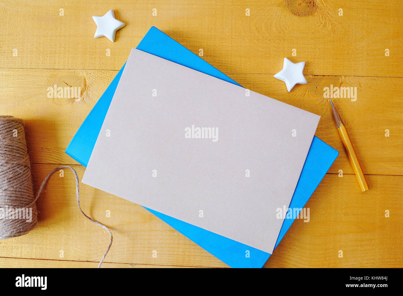 Papierbogen aus Kraftpapier mit Platz für Ihren Text auf einem blauen Notizblock. Flache Lage, Foto-Modell in Draufsicht Stockfoto