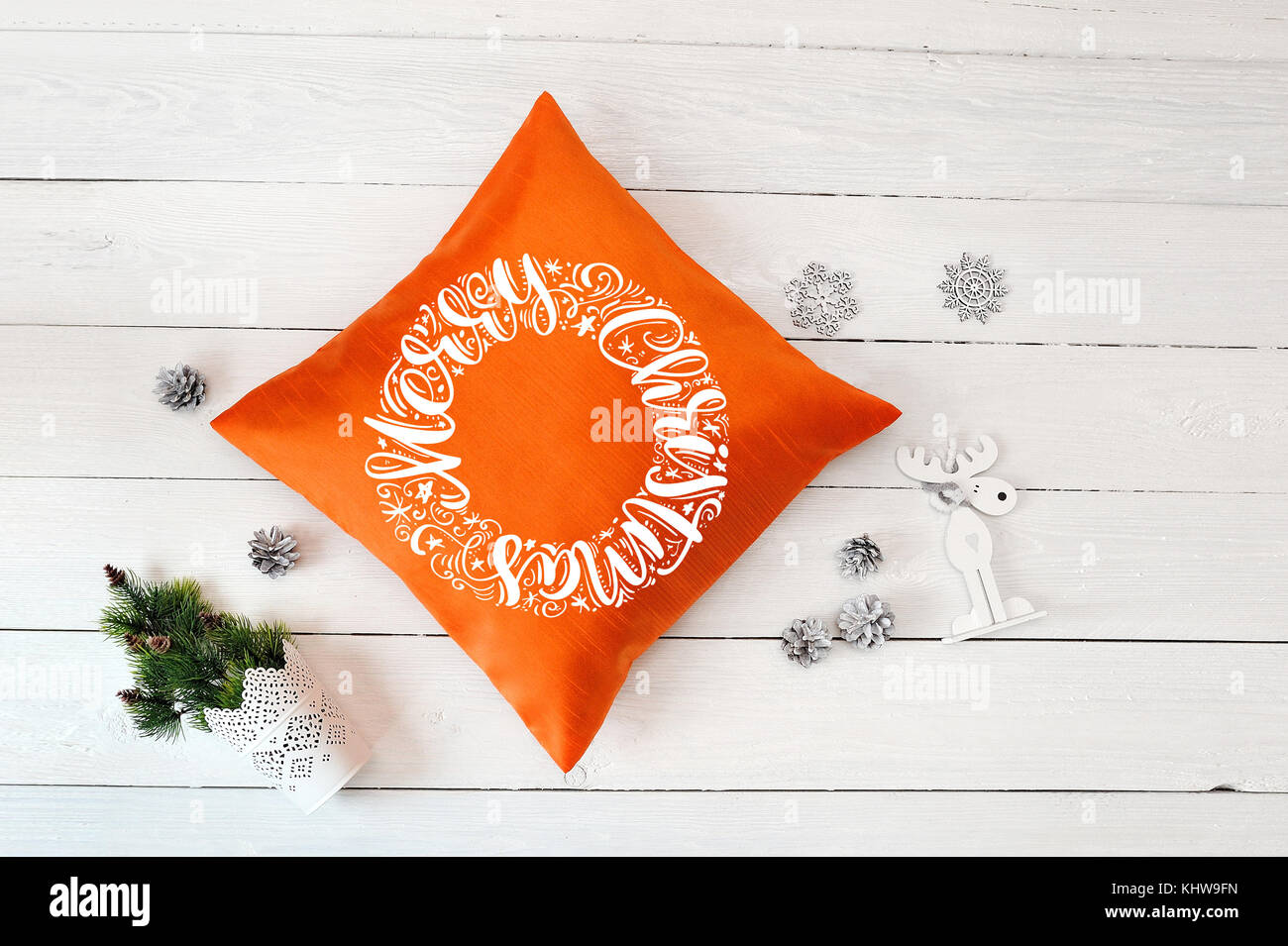Text frohe Weihnachten auf orange Kissen ein weißes Holz Weihnachten Hintergrund. Flach, Ansicht von oben Foto mockup Stockfoto