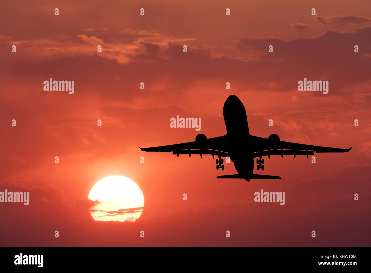 Silhouette von Flugzeug landen und Roter Himmel mit Sonne. Landschaft mit PKW Flugzeug fliegen in den Himmel mit Wolken bei Sonnenuntergang. Reisen Hintergrund. Stockfoto