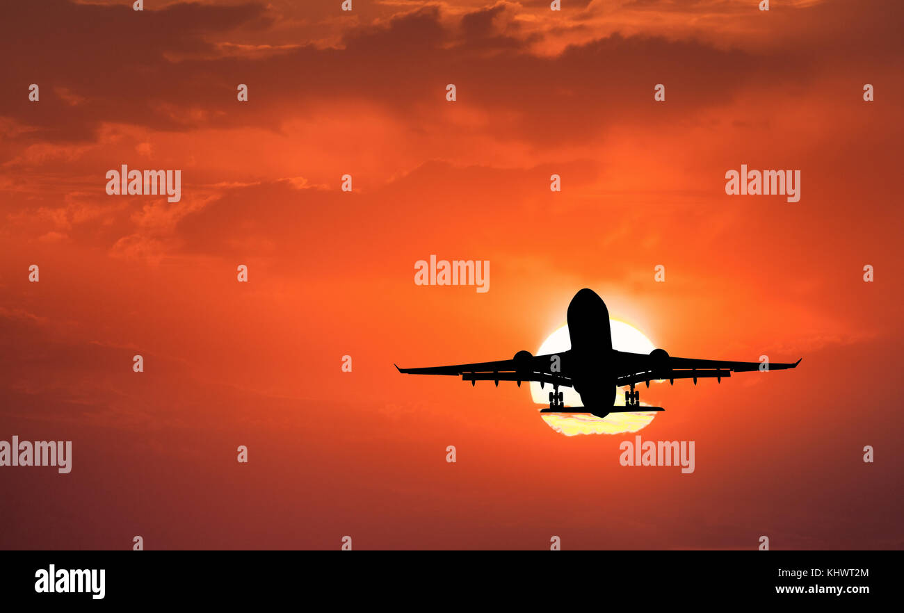 Silhouette von Flugzeug landen und Roter Himmel mit Sonne. Landschaft mit PKW Flugzeug fliegen in den Himmel mit Wolken bei Sonnenuntergang. Reisen Hintergrund. Stockfoto