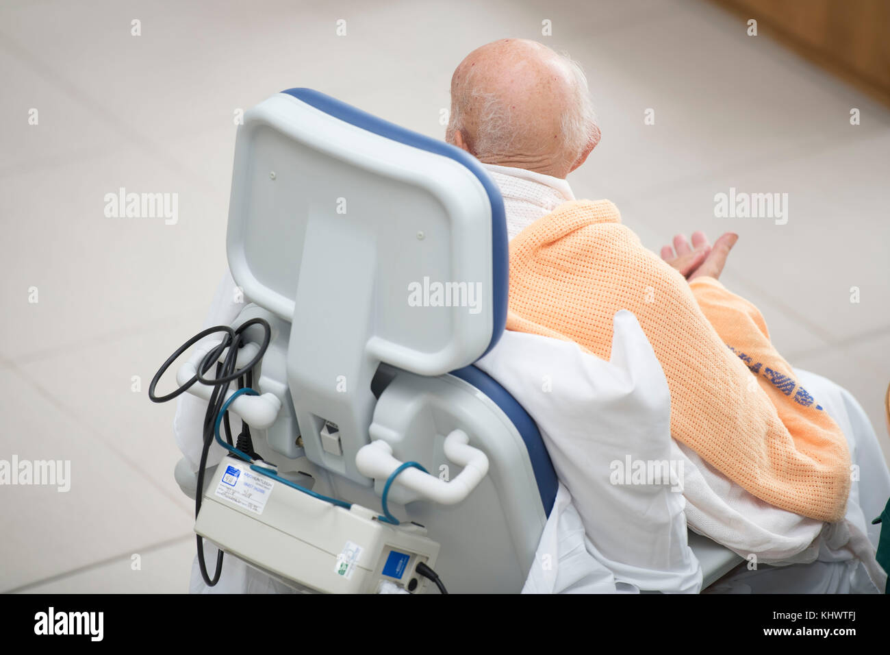 Eine ältere NHS-Patienten in einem Krankenhausbett Stuhl Stockfoto