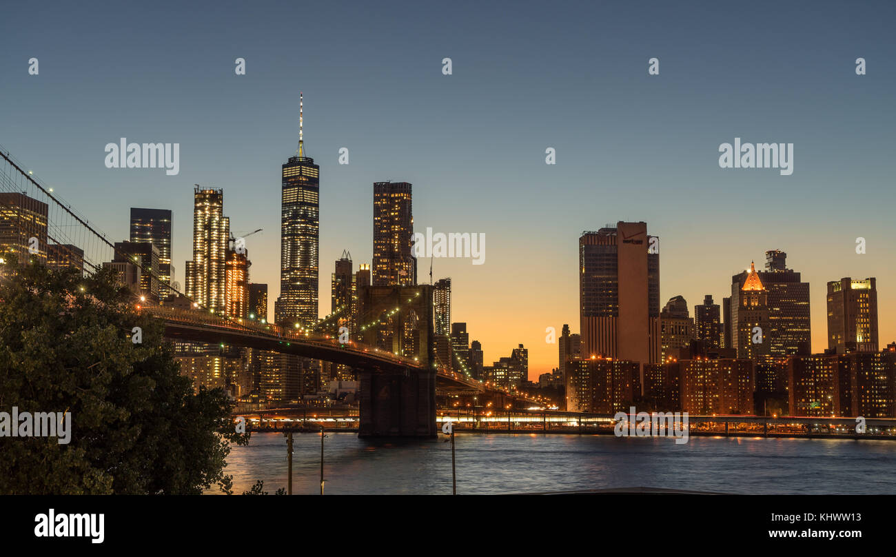 Brooklyn Bridge mit beleuchteten New York City im Hintergrund Stockfoto