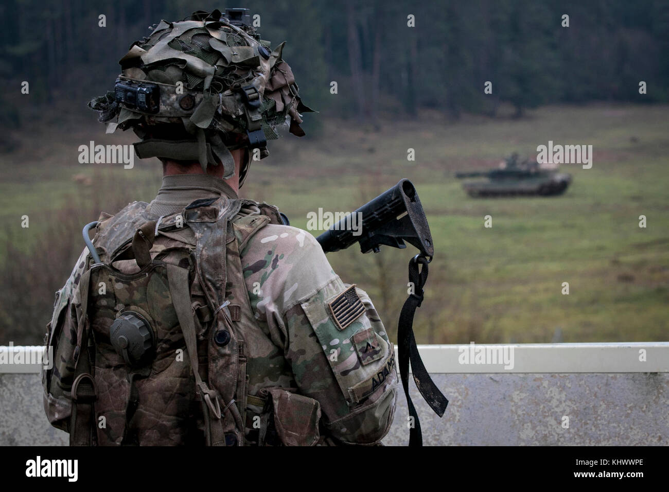 Pvt. Bundeskanzler Adams, ein infanterist mit Unternehmen C, 2nd Battalion, 70th Panzer Regiment, 2. gepanzerte Brigade Combat Team, 1.Infanterie Division in Fort Riley, Kansas starrt heraus in einem offenen Feld bei einem VORBEIFAHRENDEN M-1 Abrams Tank während der Alliierten Geist VII Training übung in Grafenwöhr, Deutschland November 17, 2017. Die US-Armee, zusammen mit seinen Verbündeten und Partnern, weiterhin eine dynamische Präsenz mit einem leistungsstarken Land Netzwerk, die gleichzeitig Aggression abhält und sorgt für die Sicherheit der Region zu schmieden. Service rund 3.700 Mitglieder aus 13 Nationen in 7th Army Training Command' gesammelt Stockfoto