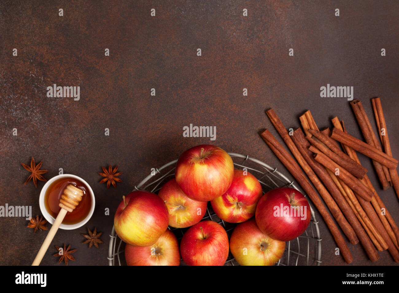 Frische Äpfel, Honig und Gewürzen: Zimtstangen, Sternanis vor einem dunklen Hintergrund. Ansicht von oben Stockfoto