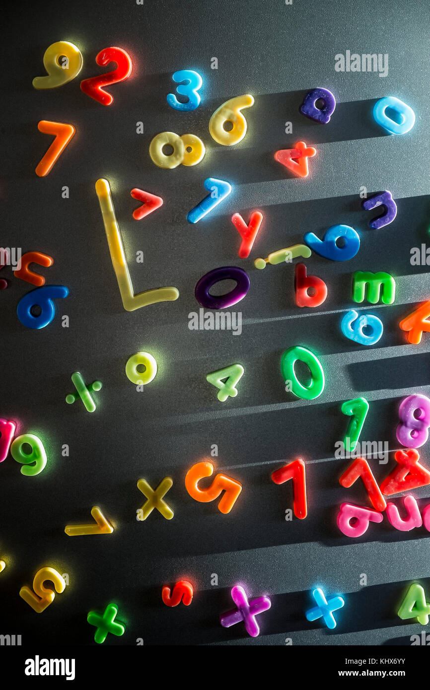 Bunte Kunststoff magnetische Buchstaben und Zahlen an einer Kühlschranktür geklebt. Stockfoto