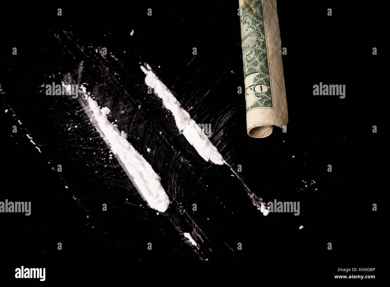 Kokain oder anderen illegalen Drogen, die durch ein Röhrchen geschnupft, auf Schwarz glänzend Hintergrund isoliert Stockfoto