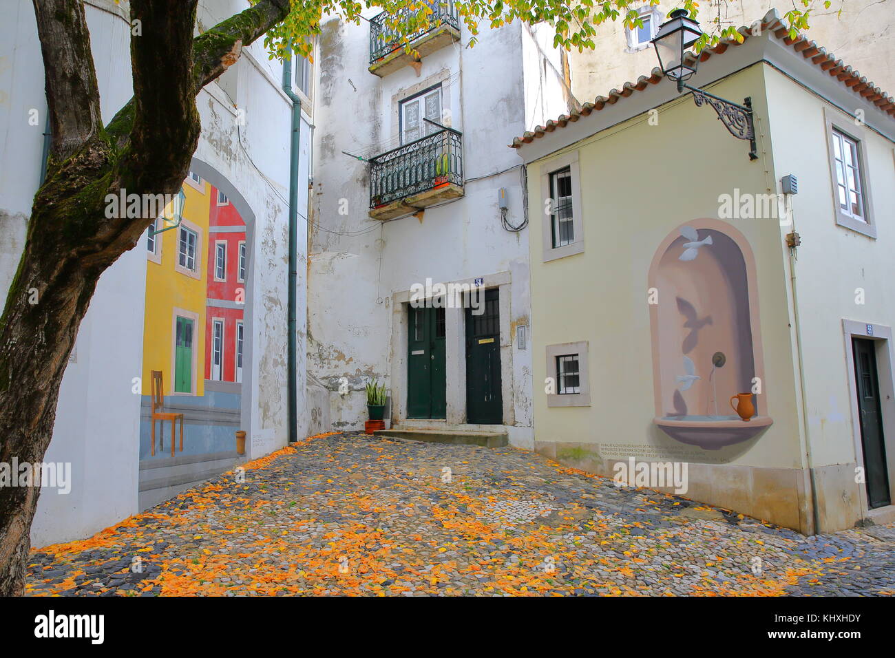 LISSABON, PORTUGAL - 2. NOVEMBER 2017: Farbenfrohe Platz- und Straßenkunst im Viertel Alfama mit Kopfsteinpflaster und traditionellen Hausfassaden Stockfoto