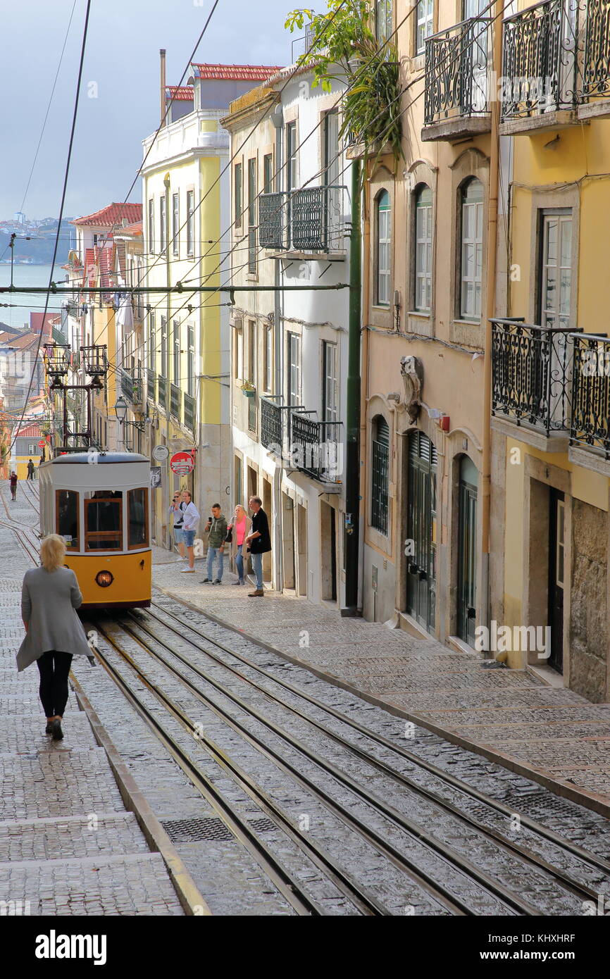 LISSABON, PORTUGAL - 4. NOVEMBER 2017: Die Standseilbahn Elevador da Bica im Stadtteil Bairro Alto mit farbenfrohen Fassaden und dem Fluss Tejo im Hintergrund Stockfoto