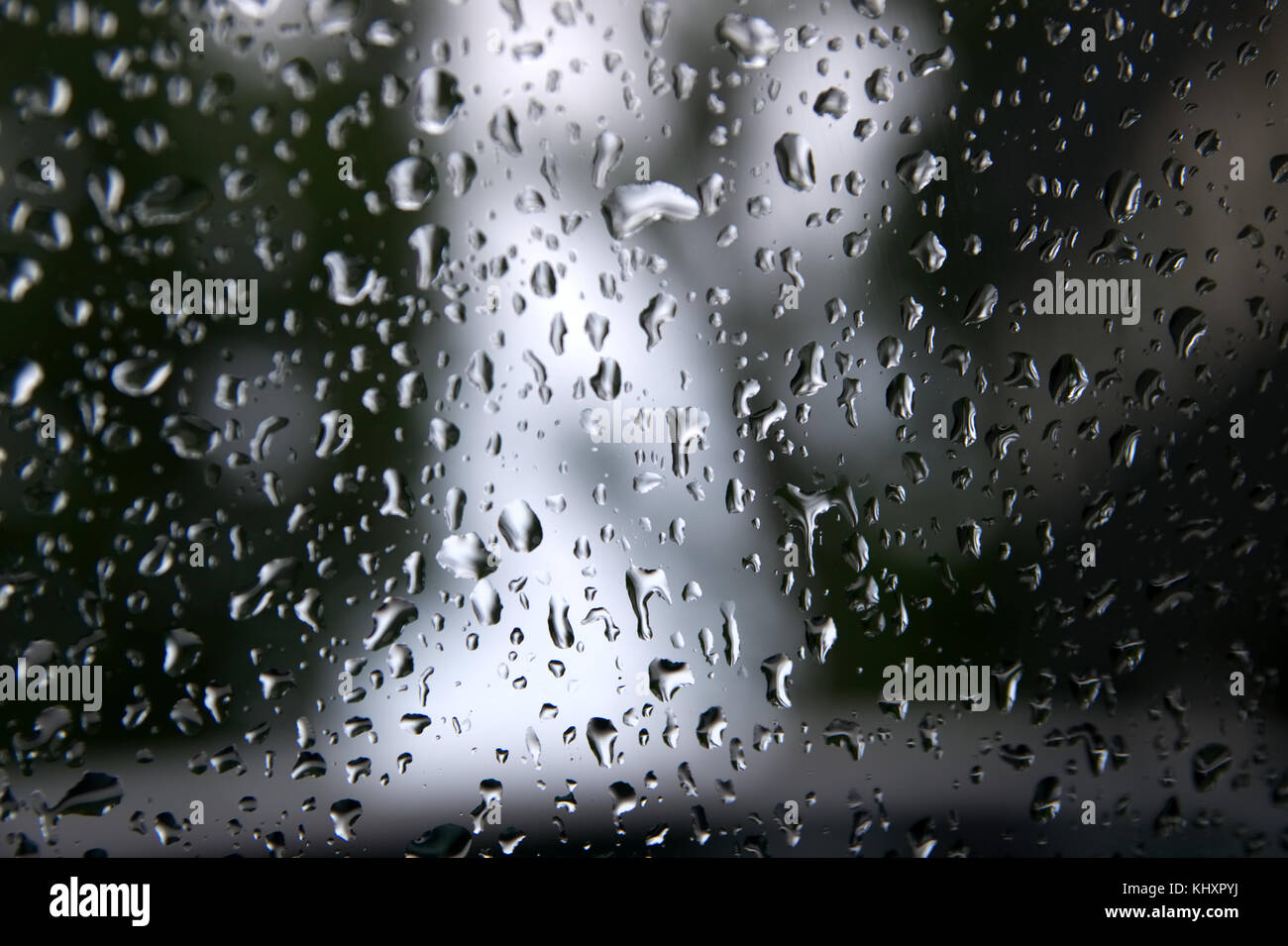 Tropfen Wasser regnet auf einer Fensterscheibe. Stockfoto