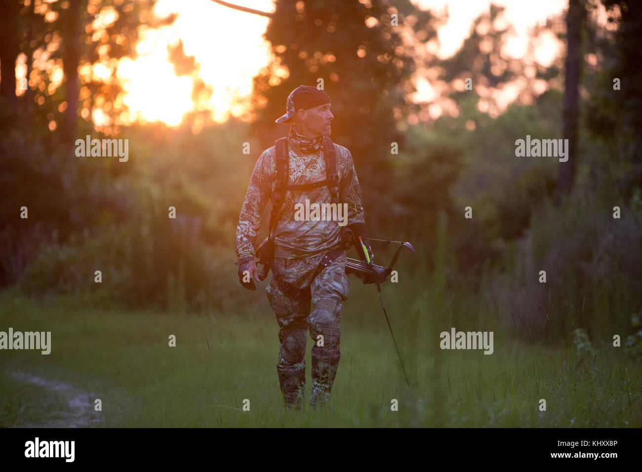 Reifer Mann Wandern in ländlicher Umgebung, mit Armbrust Stockfoto